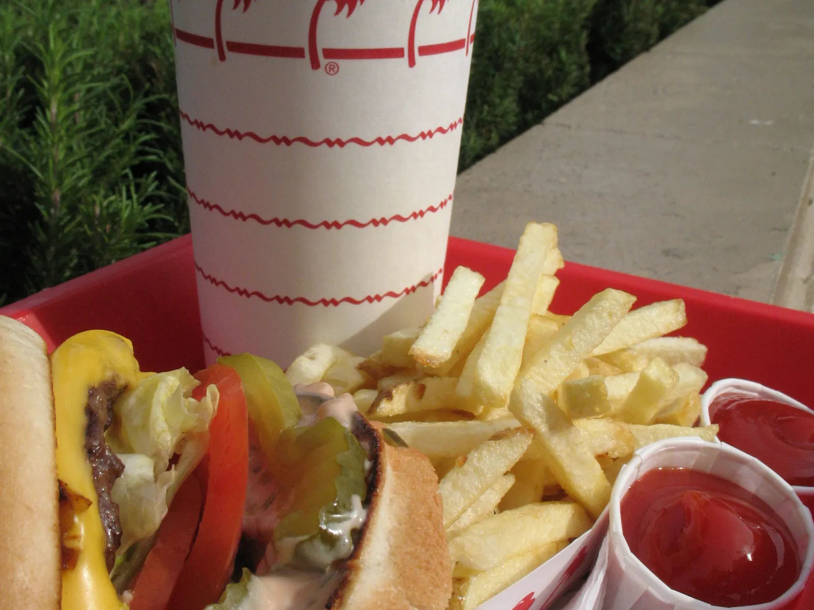 Classic cheeseburger value meal with fries and soft drink on a tray in the 2026 burger value wars