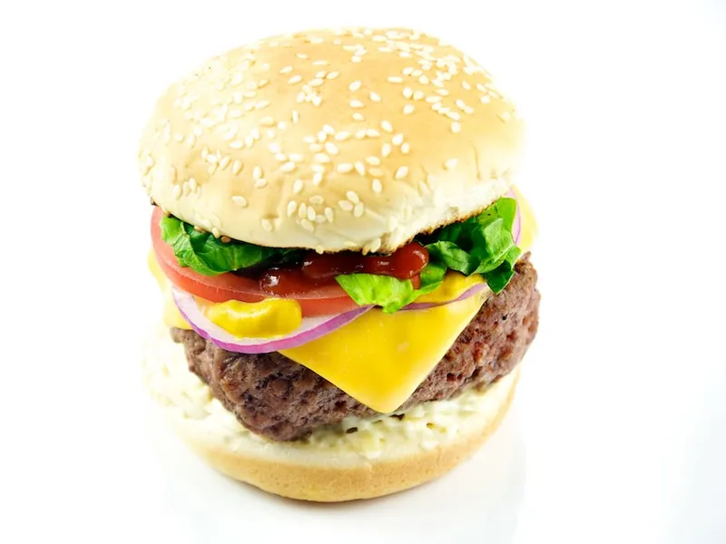 Cheeseburger with melted cheddar, lettuce, tomato and fries in a brioche bun illustrating the best burgers in Birmingham guide