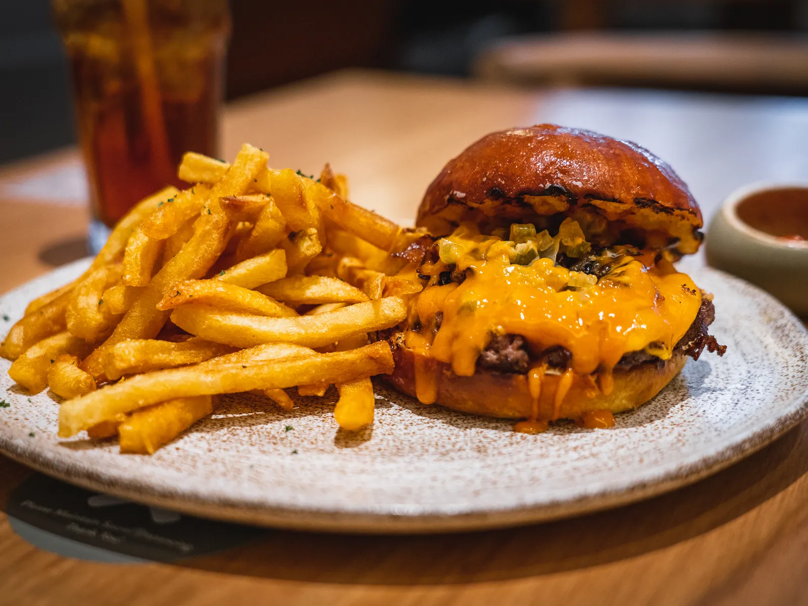 Burger in Jakarta: grass-fed beef cheeseburger with melted cheese, grilled onion and jalapeño relish, served with fries at Bakerman Cafe in South Jakarta