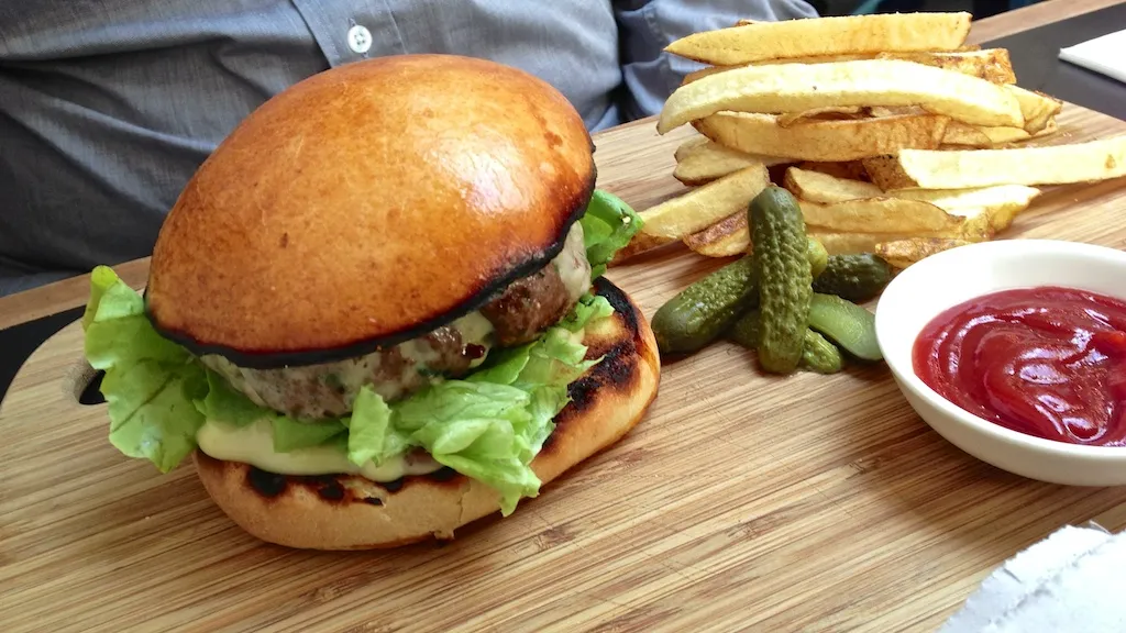 Beef burger in brioche bun with chips — illustrates Patty&amp;Bun smashed-patty cheeseburger and Tommi’s classic. Alt: Patty&amp;Bun London brioche burger with chips