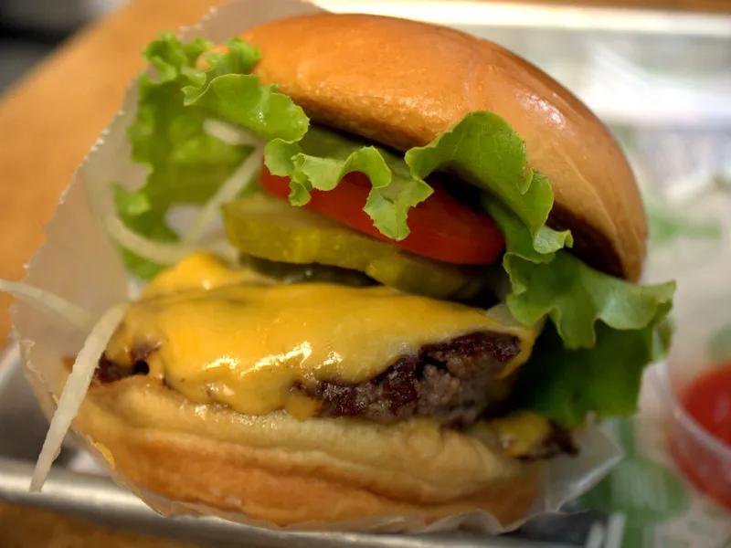 Double buff cheeseburger with melted cheddar in a brioche bun in New Delhi