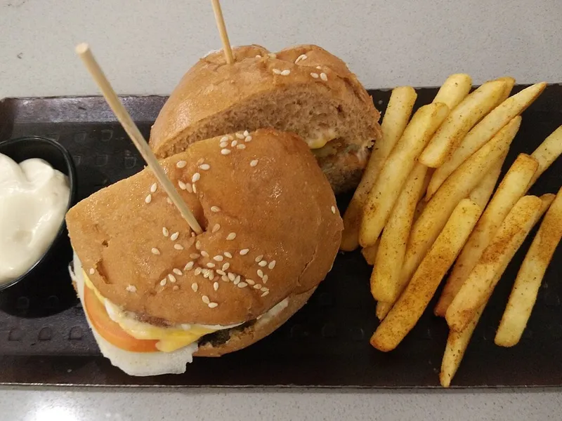 Meilleur burger à Mumbai : burger végétarien coupé en deux, frites épicées et mayonnaise au Tea Villa Cafe