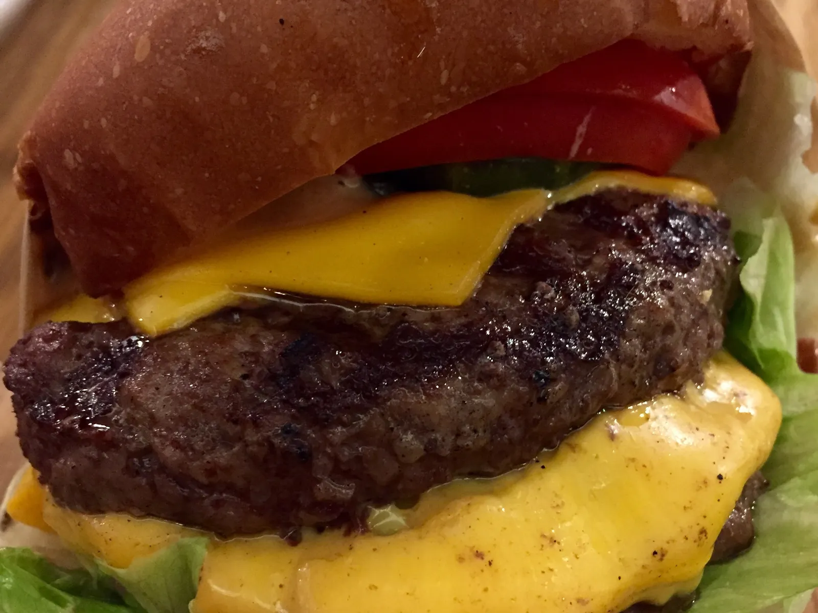 Hamburguesa doble con queso fundido y pepinillos en pan tierno, para ilustrar las mejores hamburguesas de Oporto