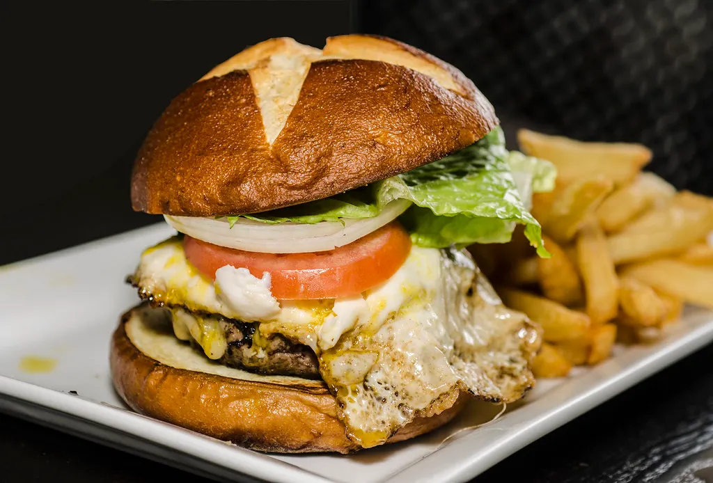 Gourmet burger with fresh-cut fries illustrating Toulouse burger guide