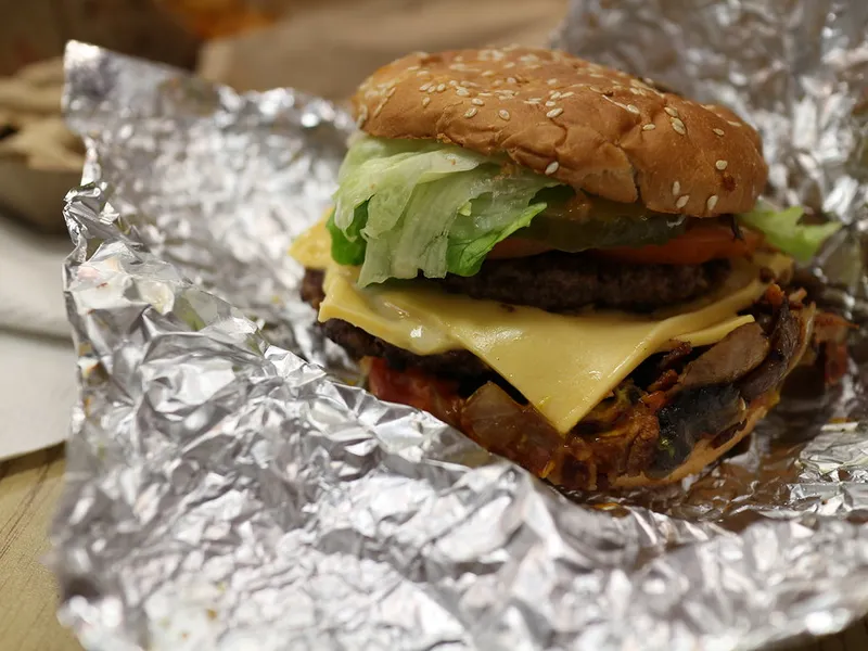 Five Guys cheeseburger with two beef patties, melted cheese and toppings on a toasted sesame bun