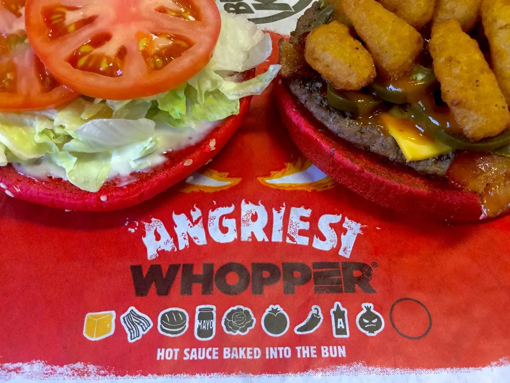 Burger King Whopper in its paper wrap, the flame-grilled burger that got a new bun, mayo and clamshell box in 2026