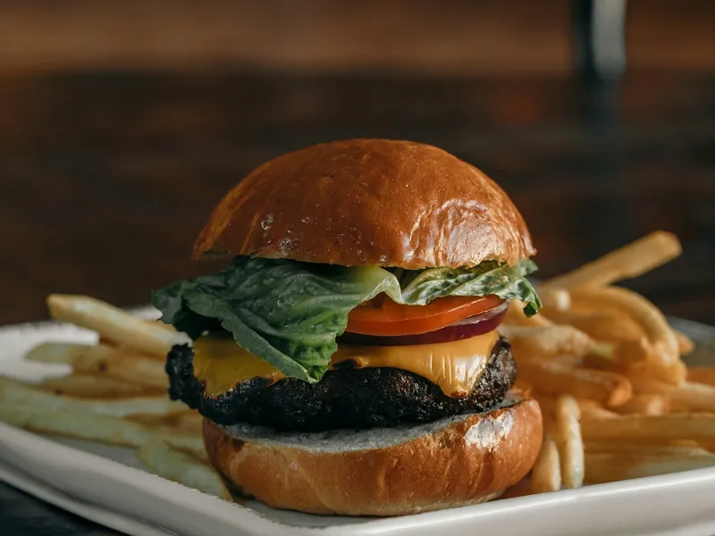 Tendances burger 2026 : cheeseburger classique et frites dans une assiette, la comfort food au cœur du retour des burgers rétro et cultes