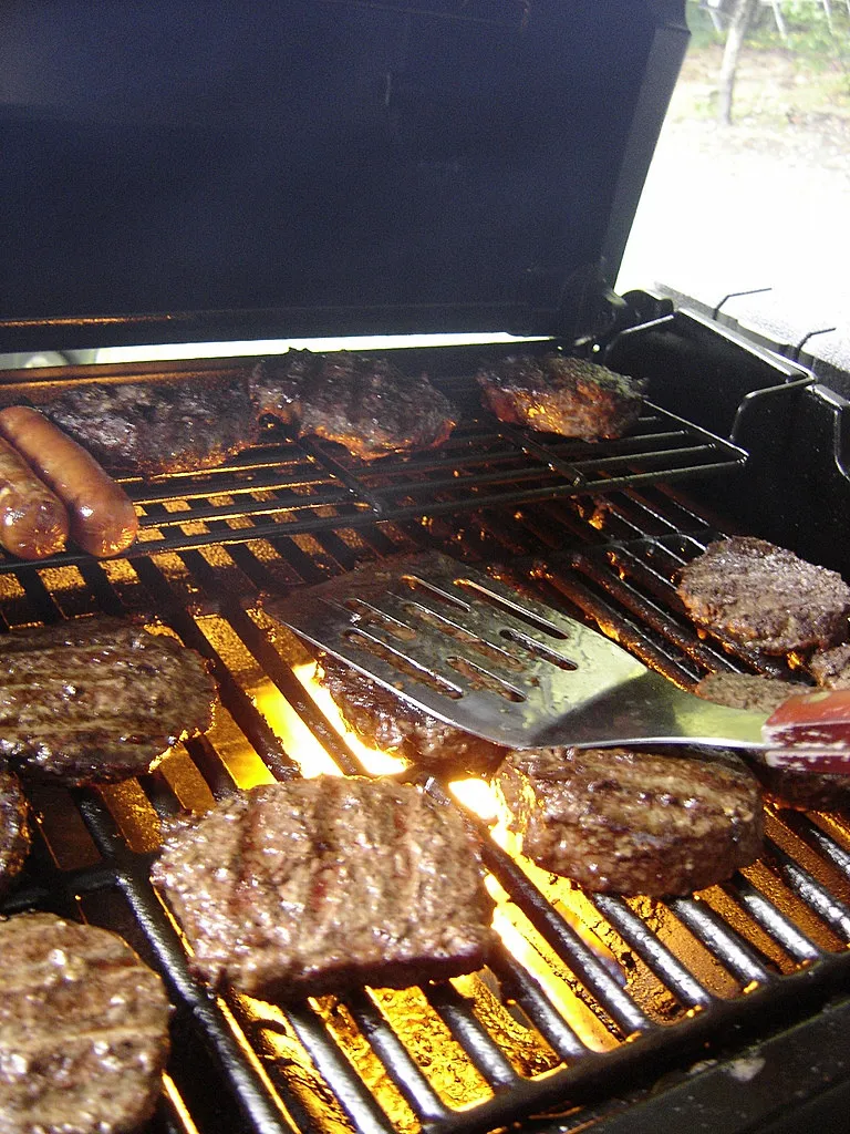 Beef patties flame-grilling over direct high heat for a Burger King style Bacon King copycat