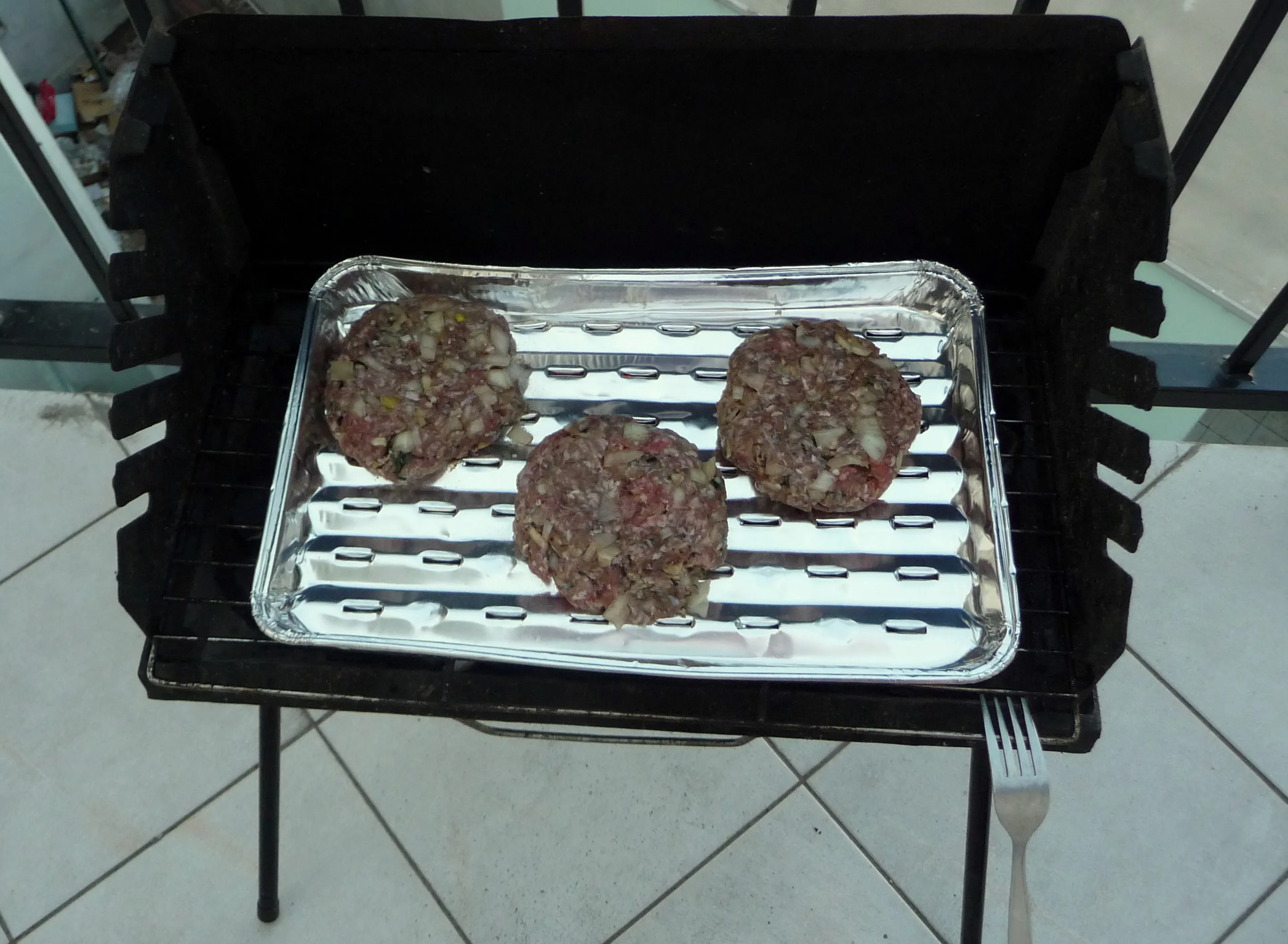 Thin homemade beef patties cooking on grill grates for a copycat Double Whopper