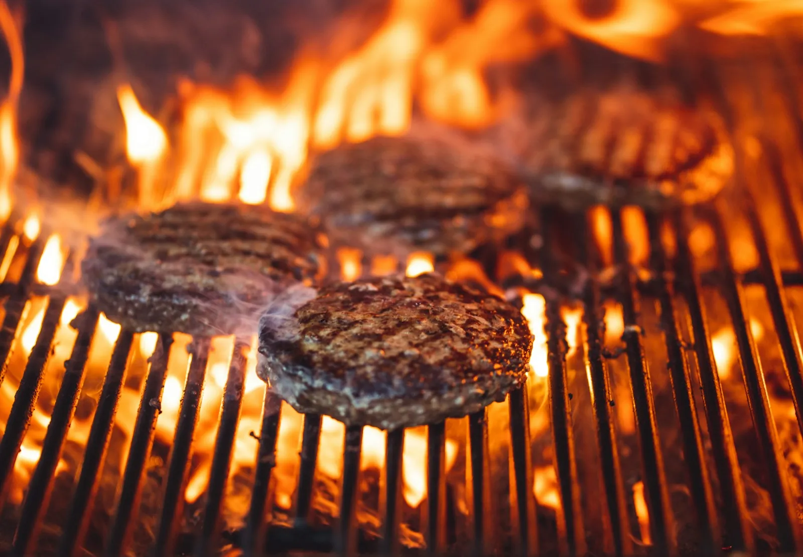 Beef burger patty searing over high direct heat for a charbroiled Famous Star taste
