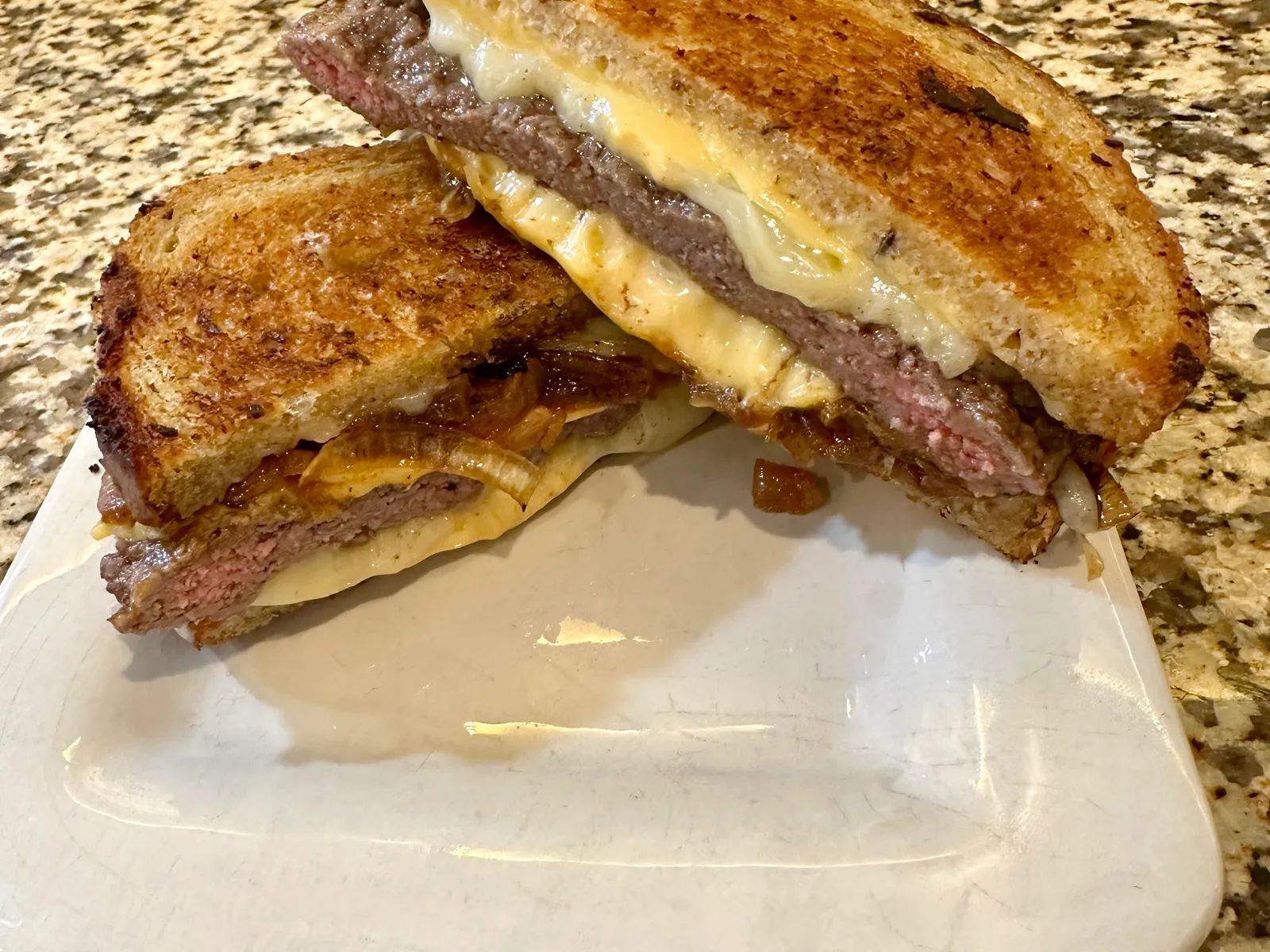 Homemade patty melt cut on the diagonal, showing melted cheese and a griddled beef patty between toasted, buttered slices of bread, the build behind a Culver's Sourdough Melt copycat