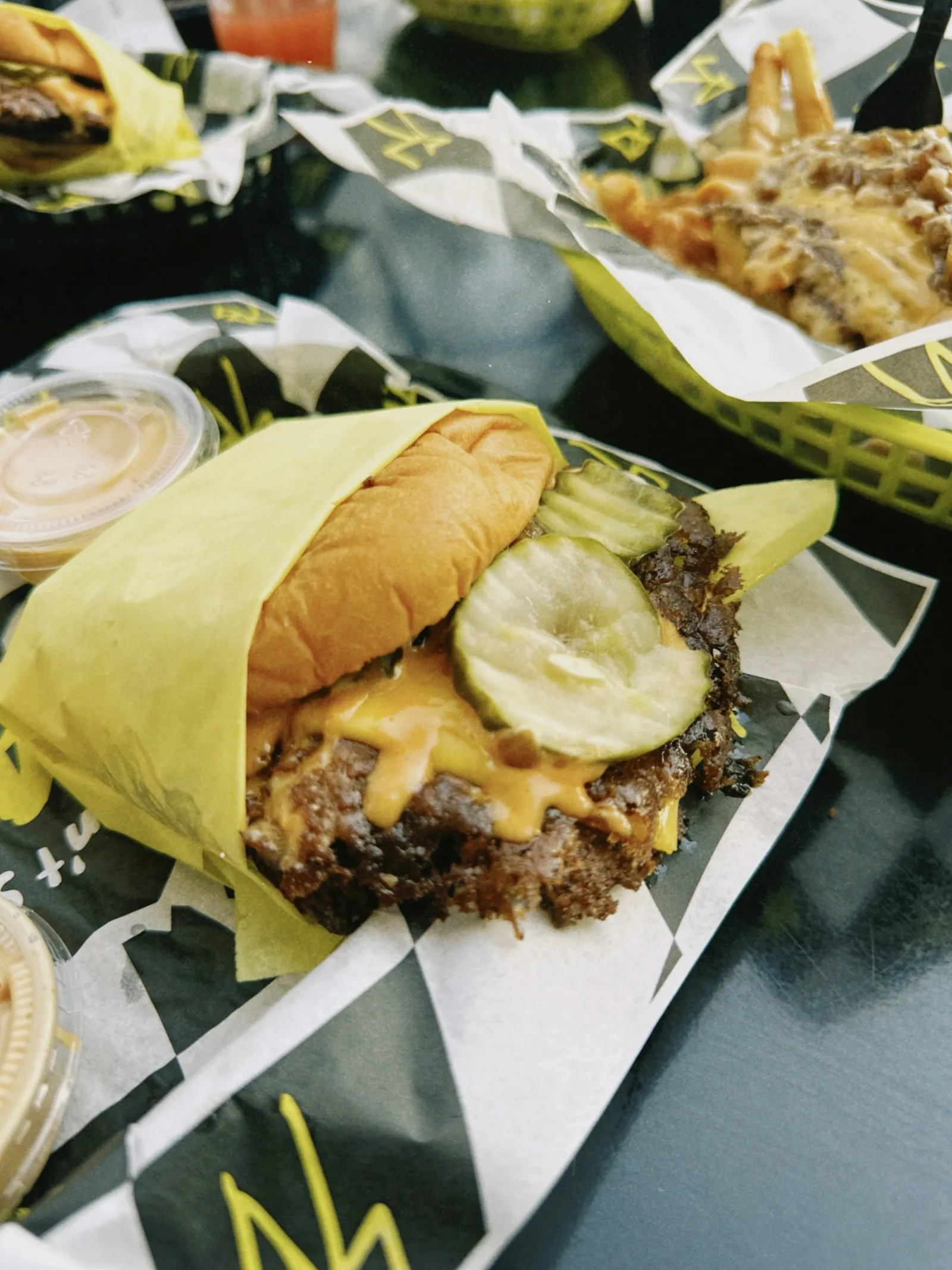 Dill pickle chips on melted American cheese over a smashed beef patty