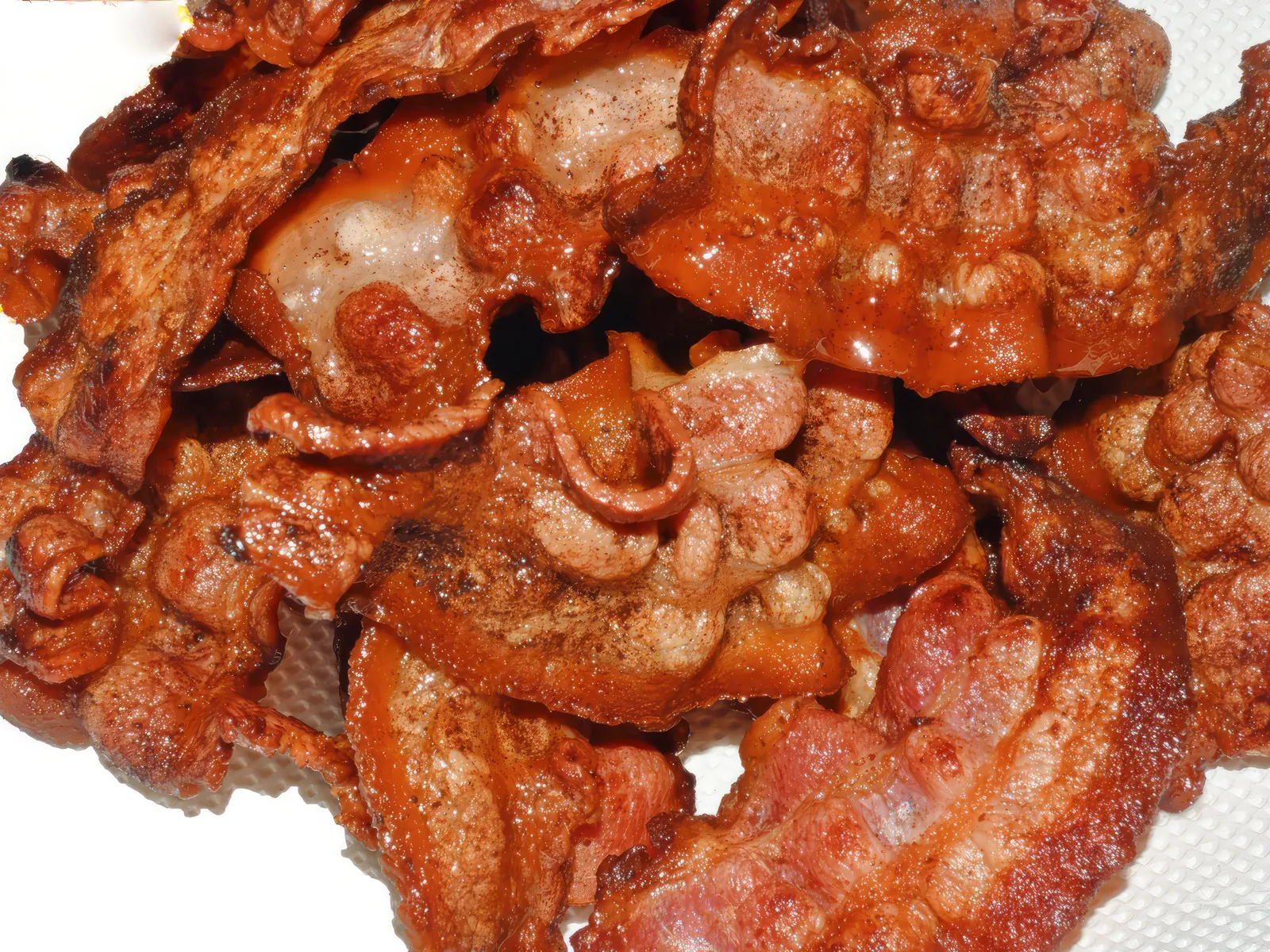 Crispy applewood-smoked bacon strips draining on a paper towel for a homemade Five Guys Bacon Burger copycat