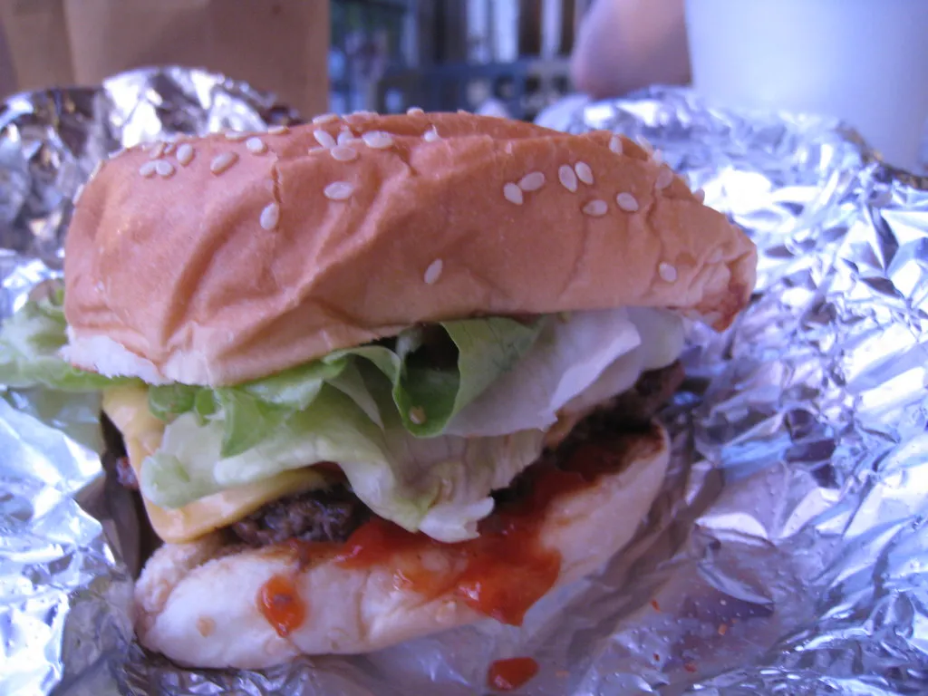 Cheeseburger de Five Guys tal y como se sirve, con doble filete y queso fundido en pan con sésamo