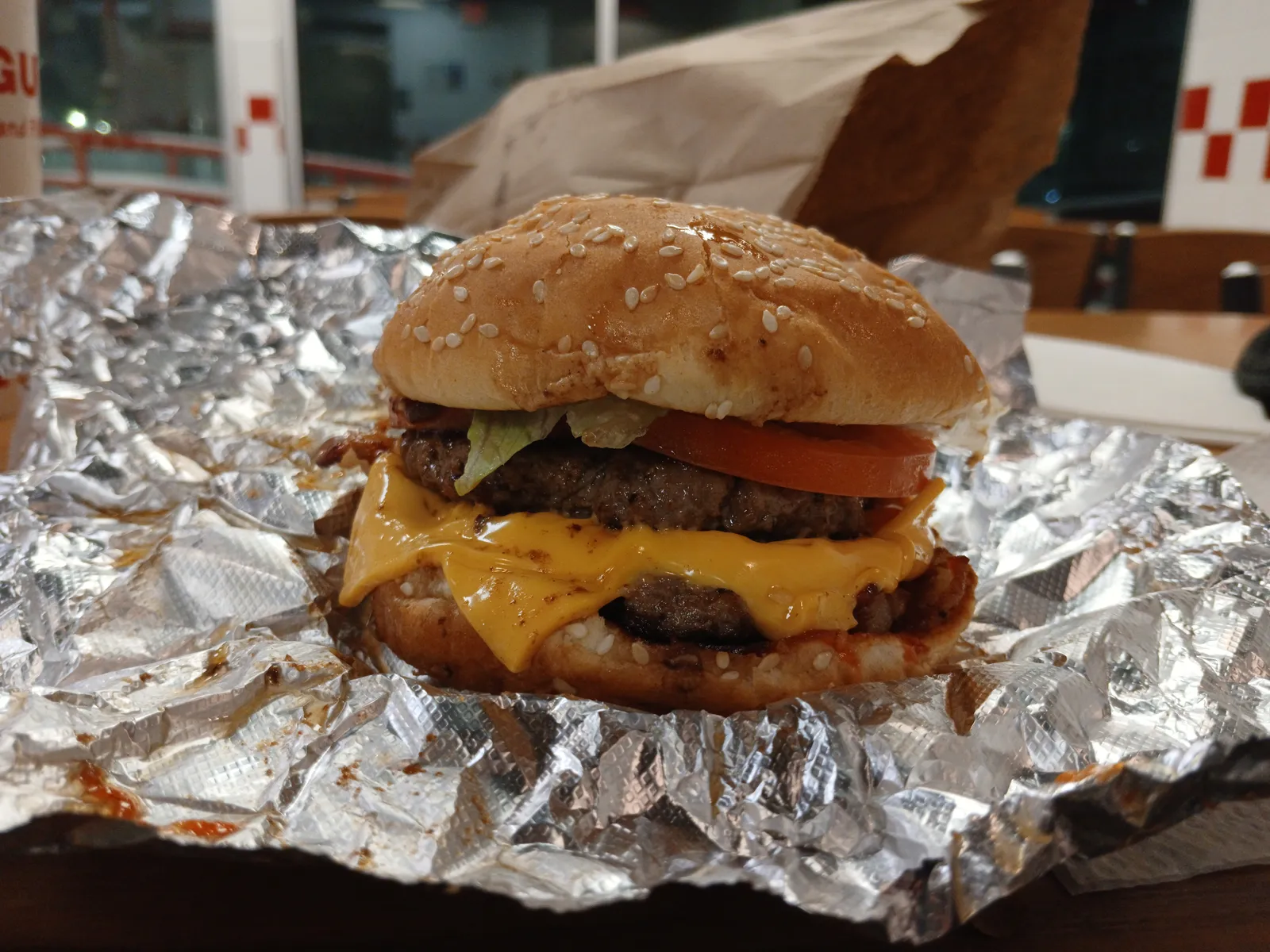 Five Guys bacon cheeseburger with melted American cheese and crispy applewood-smoked bacon on a sesame bun, served on its aluminum foil