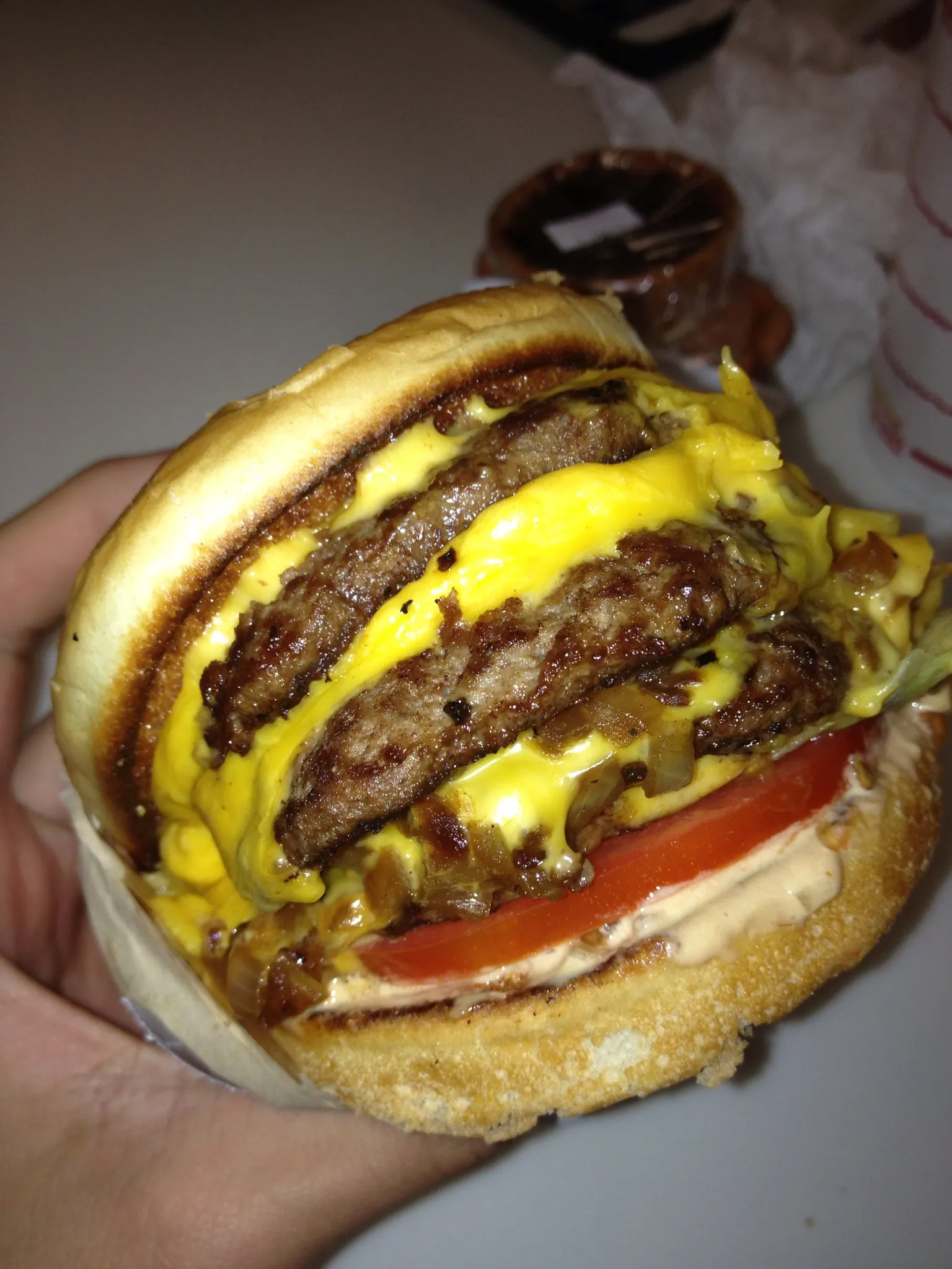 Four-patty cheeseburger showing the height of four thin stacked beef patties, as in a homemade Double Big Jack