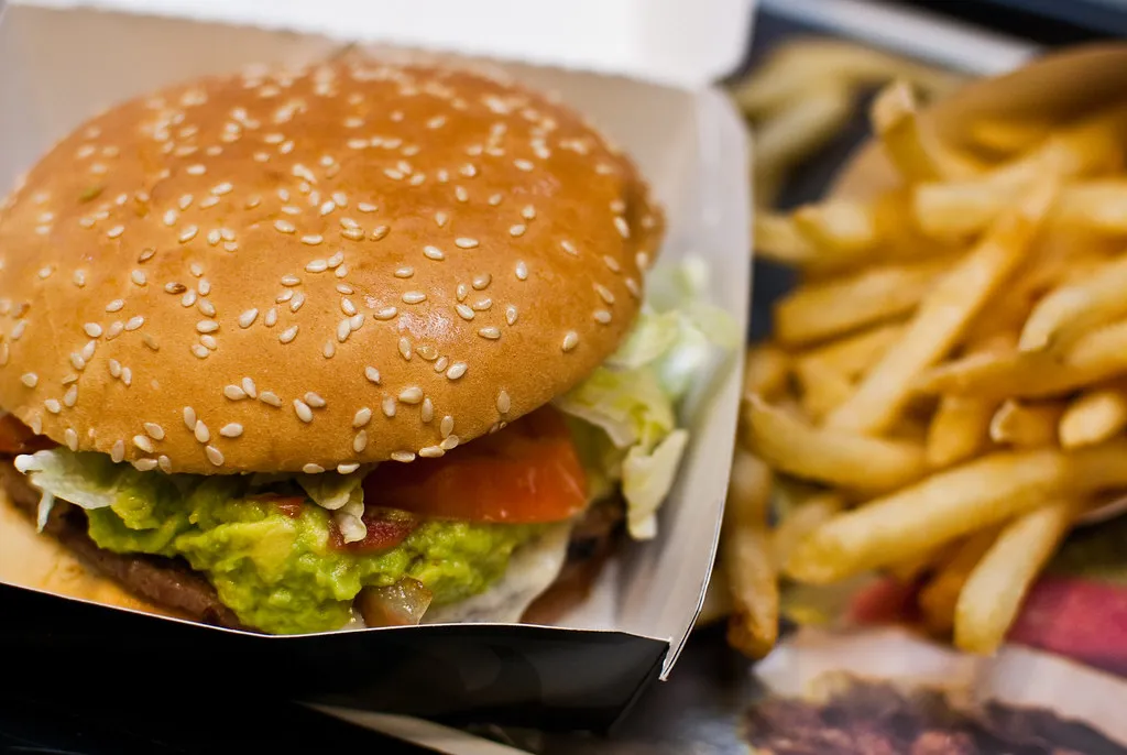 Whopper on toasted sesame bun with lettuce and tomato, showing official mayo plus tomato sauce salad build