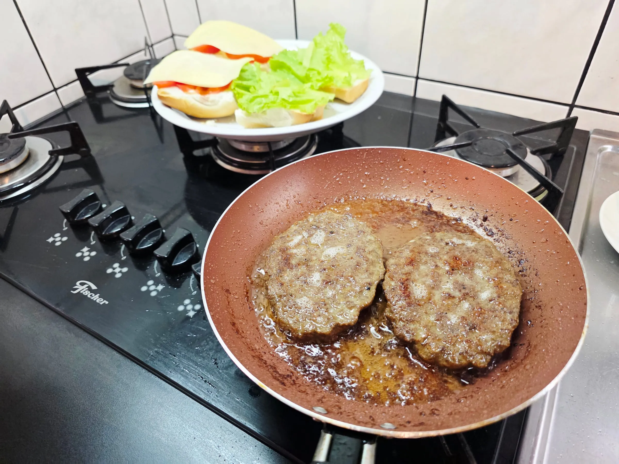 Deux steaks hachés qui cuisent dans une poêle pour un Jumbo Jack maison