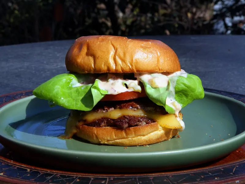 Double smash cheeseburger maison, fromage fondu, tomate, salade et sauce crémeuse dans un pain moelleux, la base de cette recette Sonic Smasher bacon maison