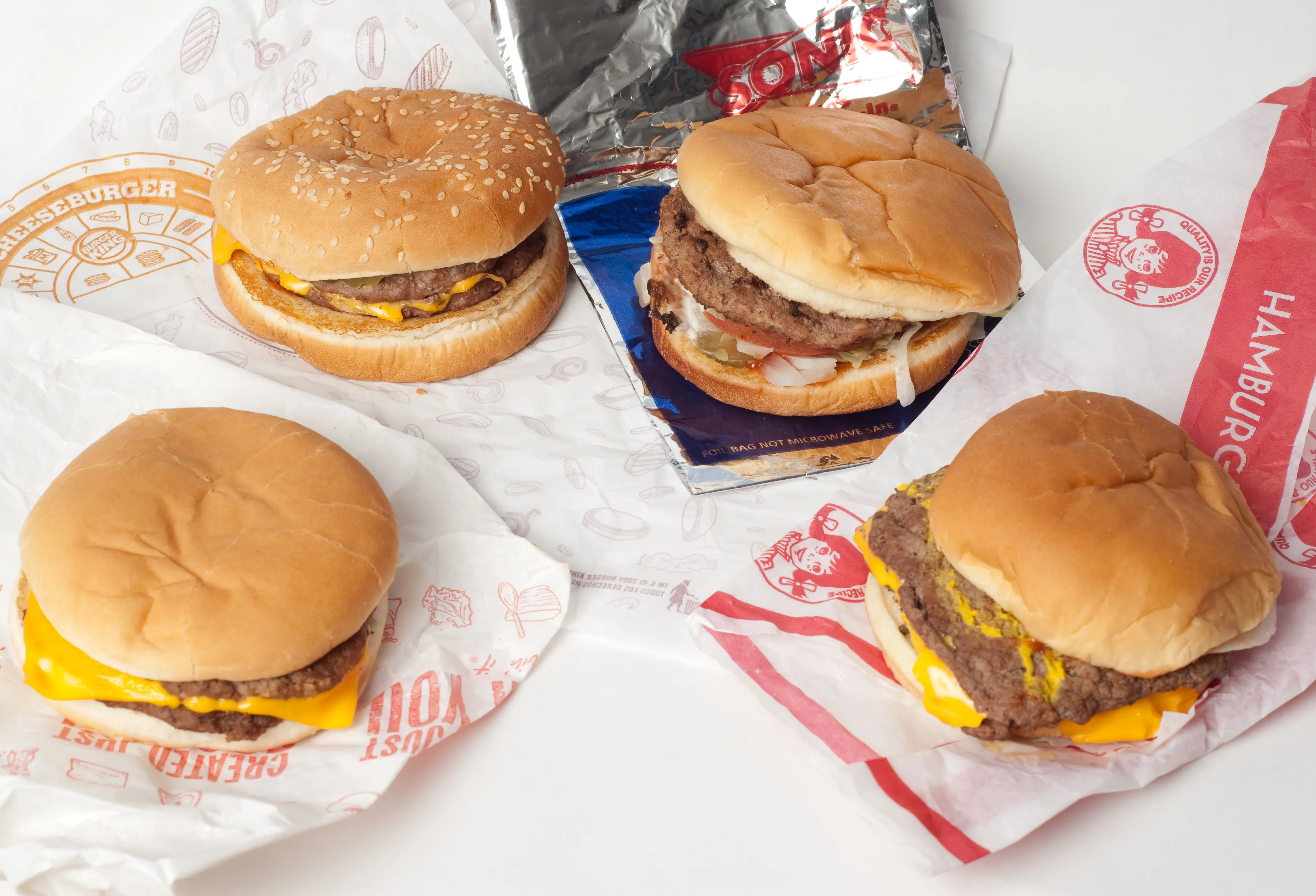 Four American value-menu cheeseburgers side by side: McDonald’s McDouble, Burger King Buck Double, Sonic Jr. Deluxe and Wendy’s Double Stack