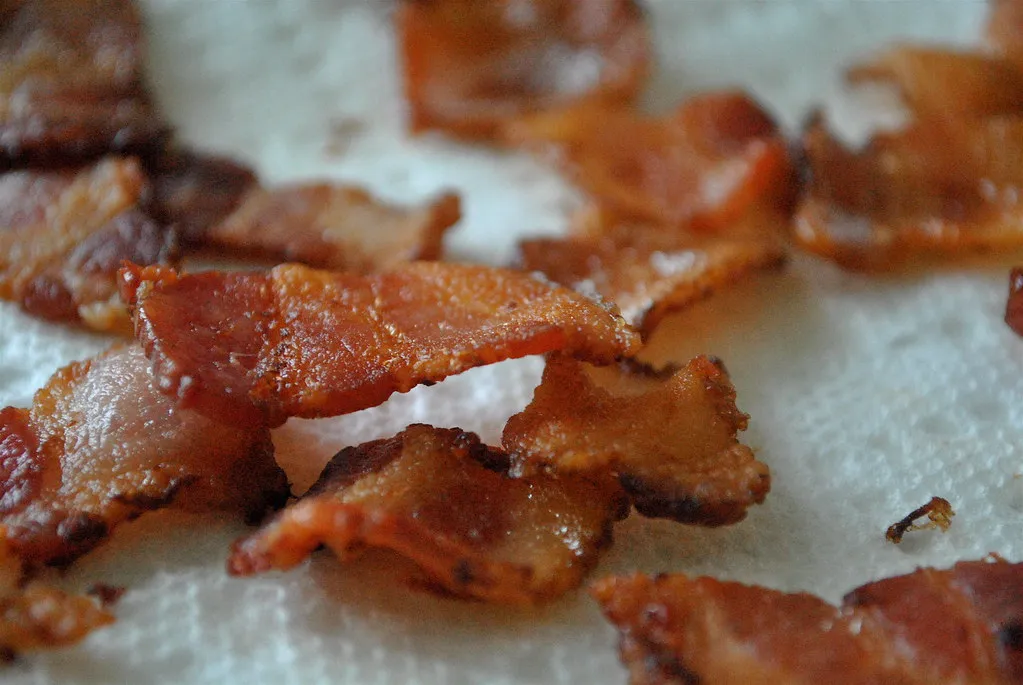Crisp cooked bacon draining on paper towels before topping the copycat double cheeseburger