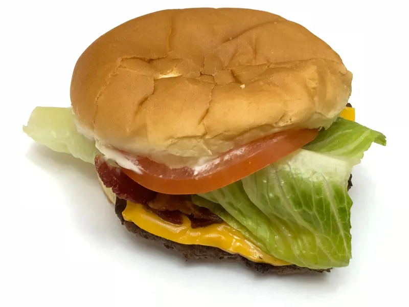 Jr. Bacon Cheeseburger de Wendy's avec steak carré qui dépasse du pain, fromage fondu, bacon, salade, tomate et mayonnaise, modèle de la recette maison