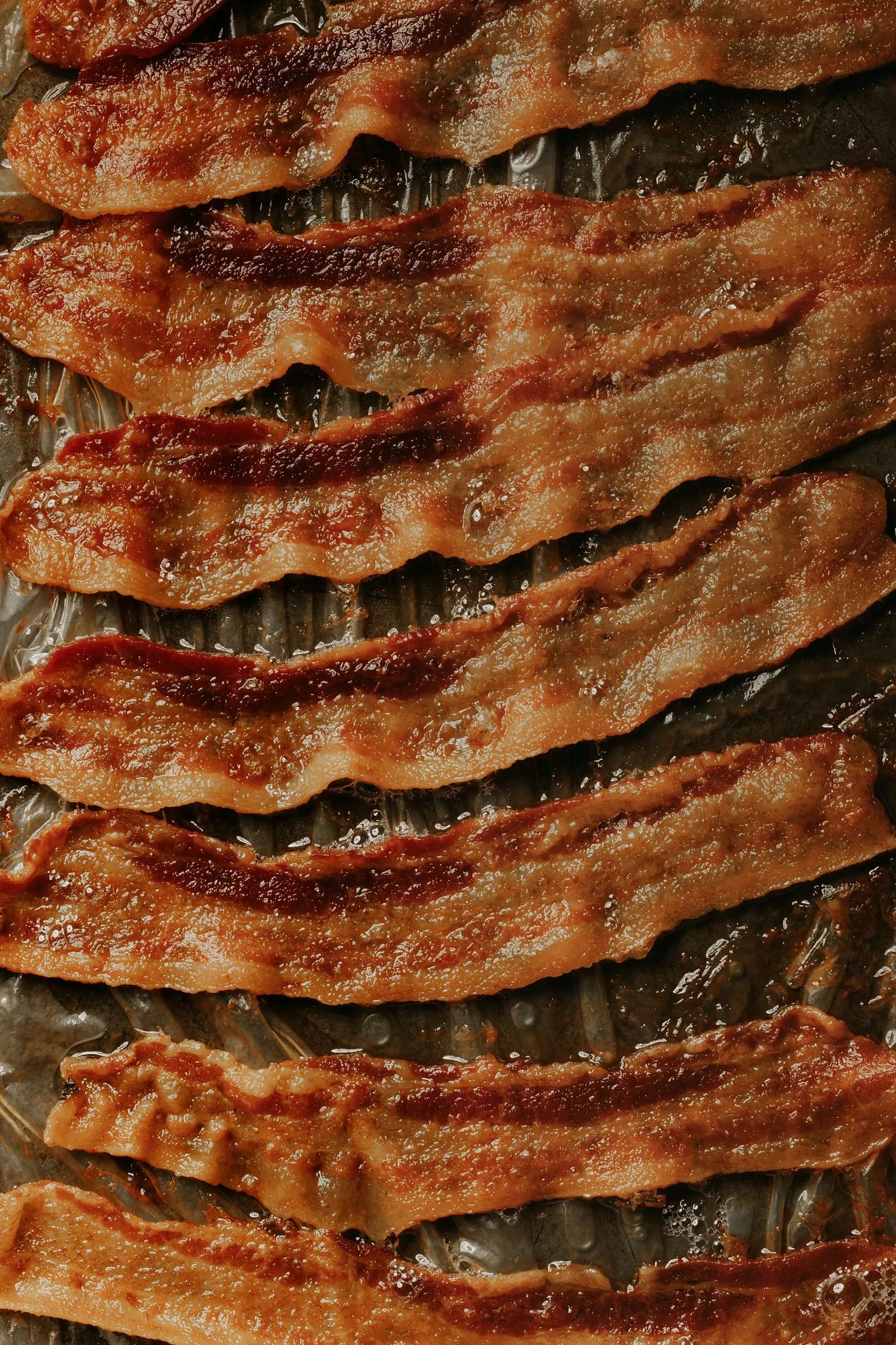 Smoked bacon strips baked flat on a sheet pan for a Jr. Bacon Cheeseburger copycat