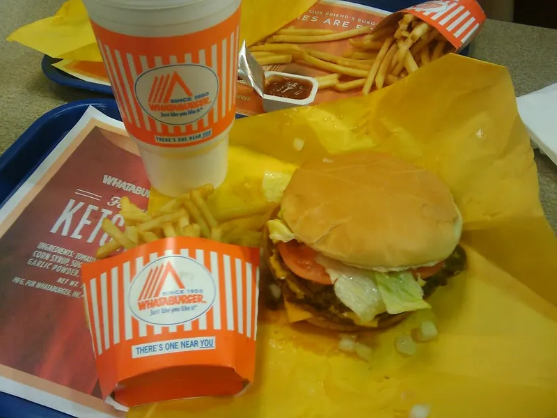 Multi-patty Whataburger with cheese, tomato, lettuce and diced onions on a Whataburger tray with fries, the model for this triple meat Whataburger copycat