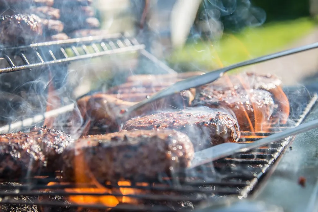 Beef patties searing on a very hot griddle over medium-high heat, 3 to 4 minutes per side to 160°F