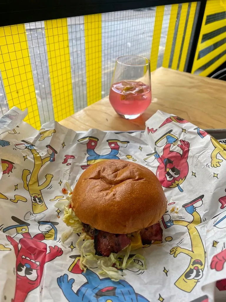 Burger au bacon et à la laitue d’Original Patty Men sur son papier illustré, à Digbeth
