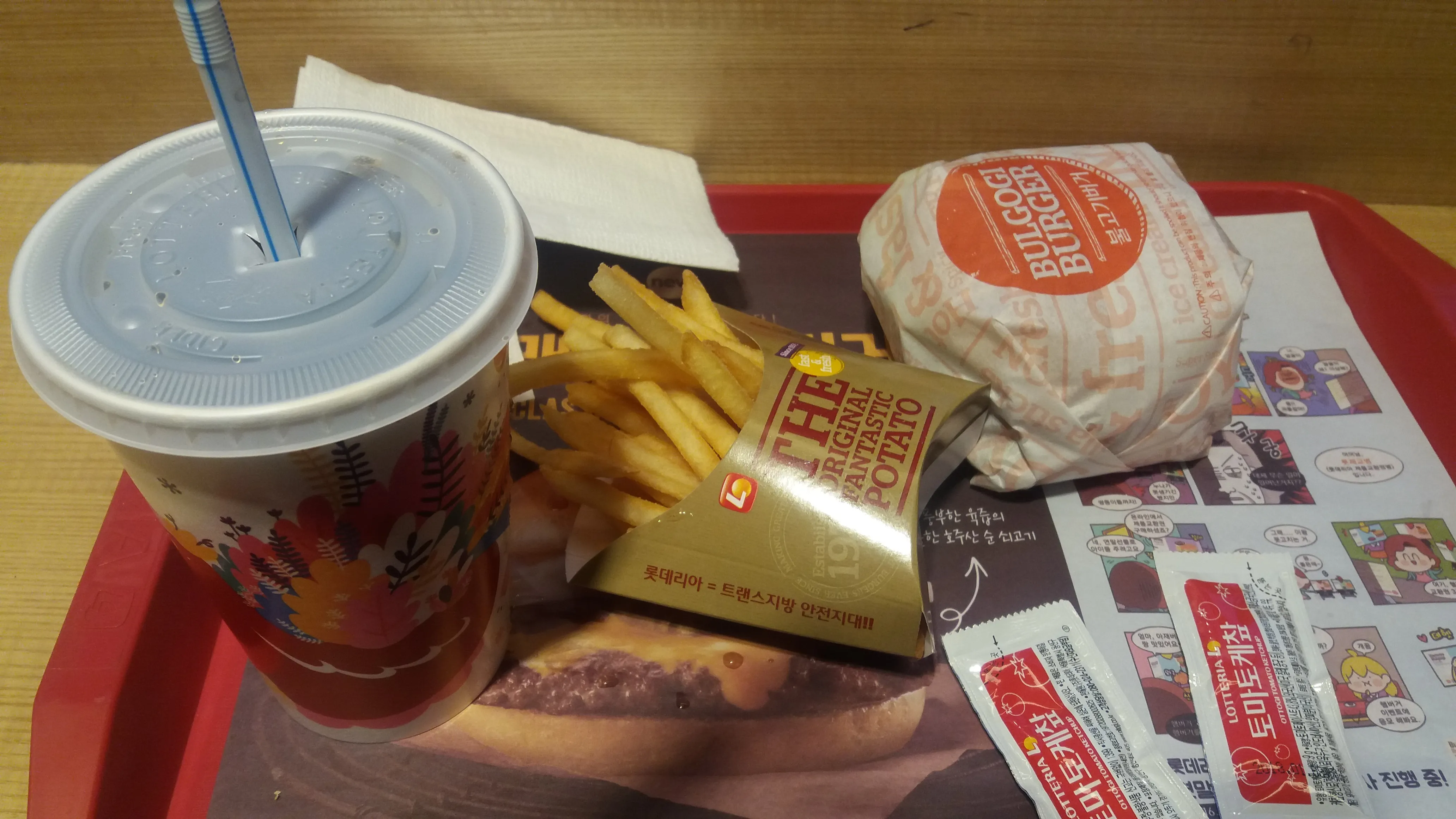 Lotteria bulgogi burger set in South Korea with fries and a cola on a red Lotteria tray