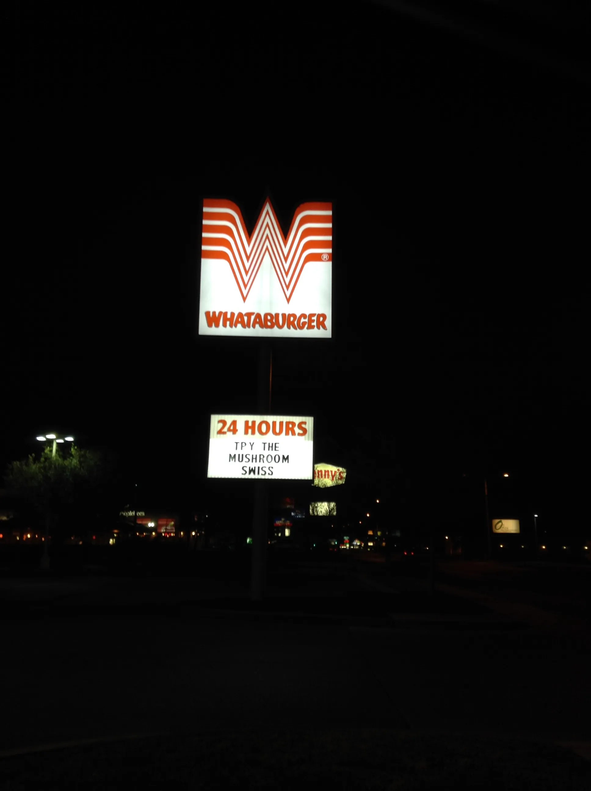 Whataburger open 24 hours: lit W pole sign and 24 Hours marquee at night