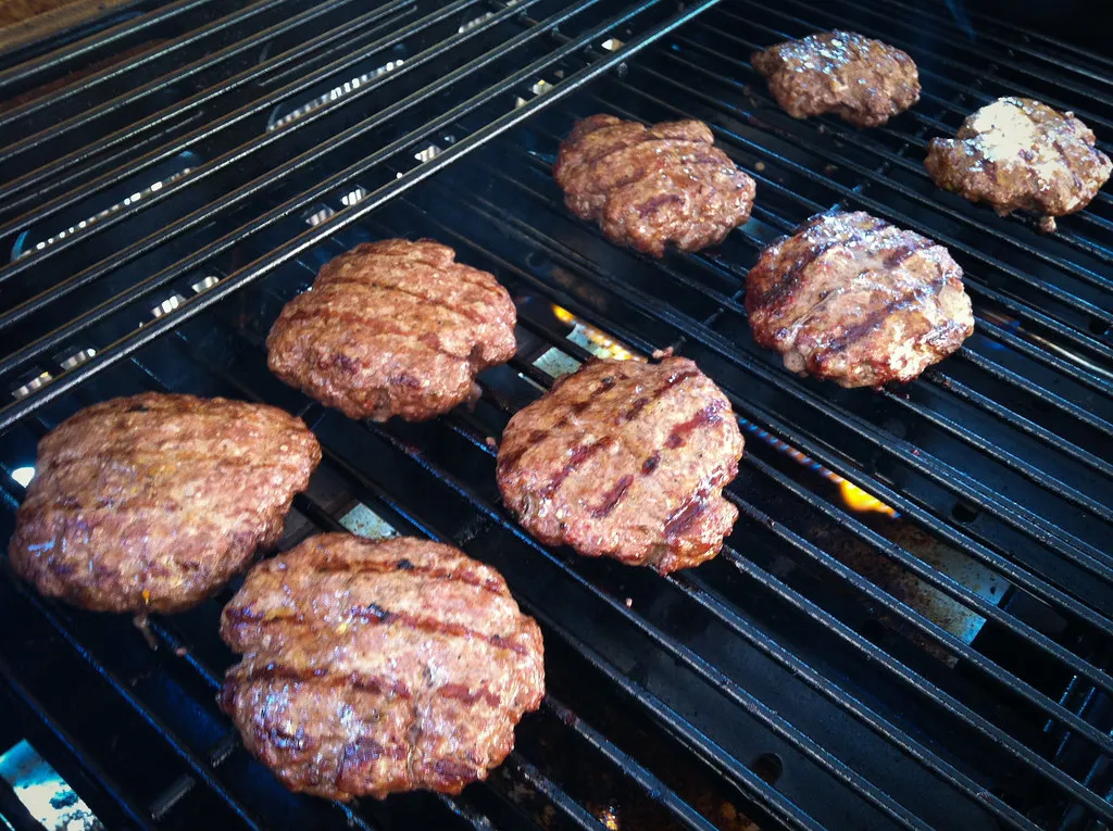 Beef burger patties grilling over charcoal, the cooking method used at 2080 Burger in Bali