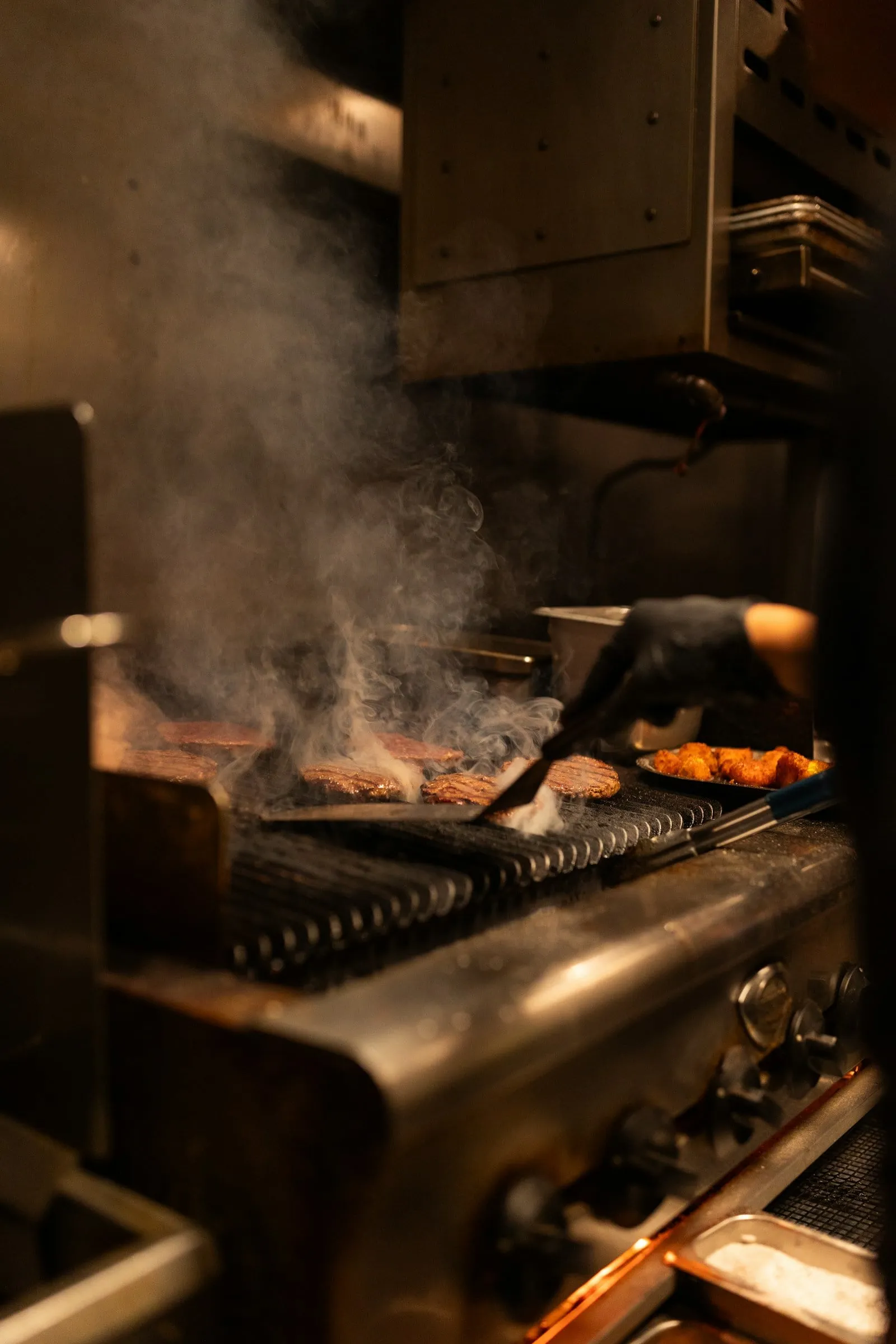Cuisinier au gril au feu de bois d’un restaurant, à l’image du gril au bois de pommier de No.7 Balmac à Dunedin
