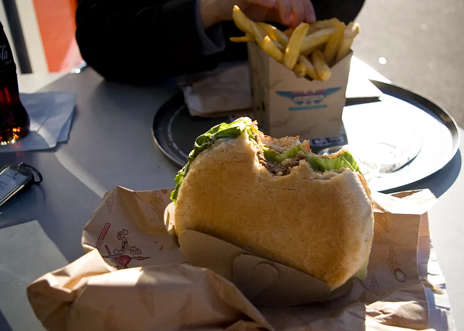 Half-eaten BurgerFuel beef burger in its cardboard Doofer holder with BurgerFuel fries, photographed at BurgerFuel Rotorua