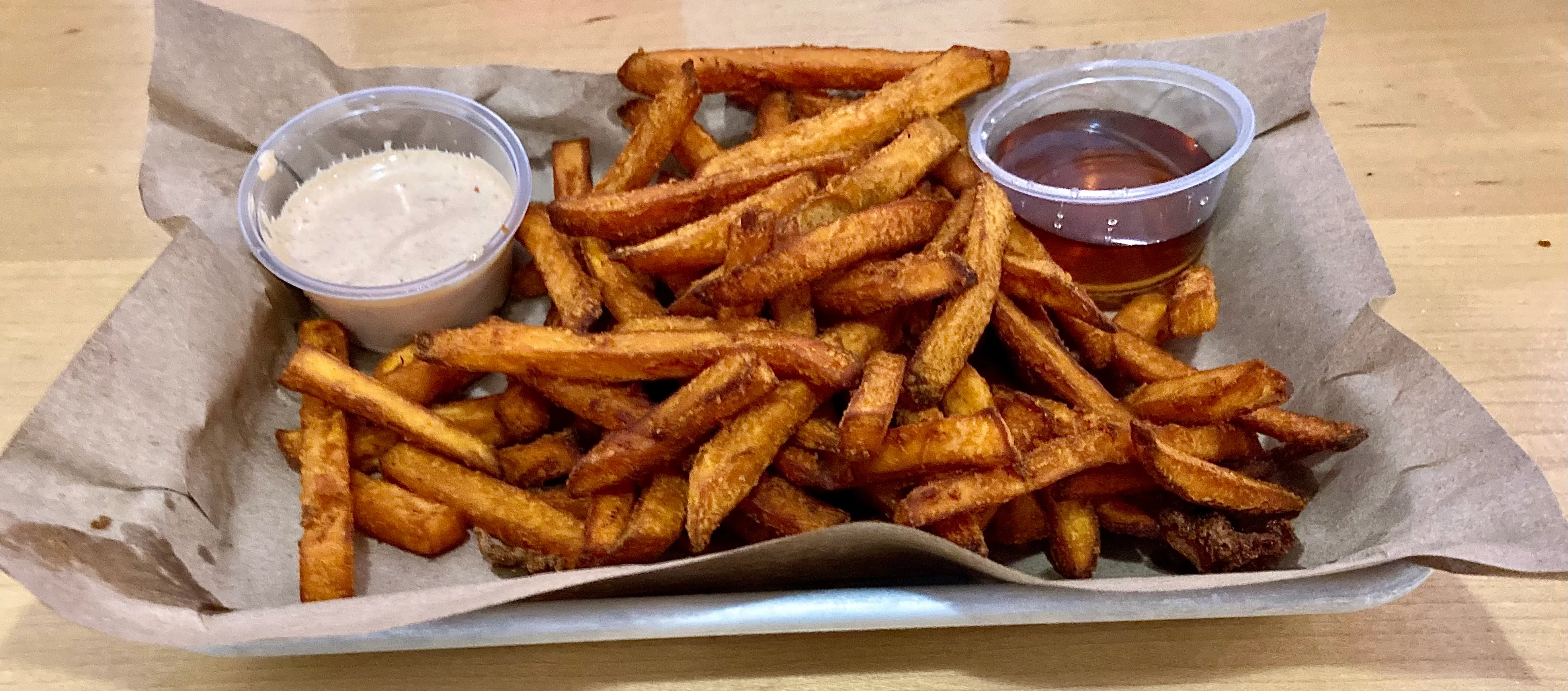 Tray of sweet potato fries with dipping sauces, similar to BurgerFuel kūmara fries with aïoli