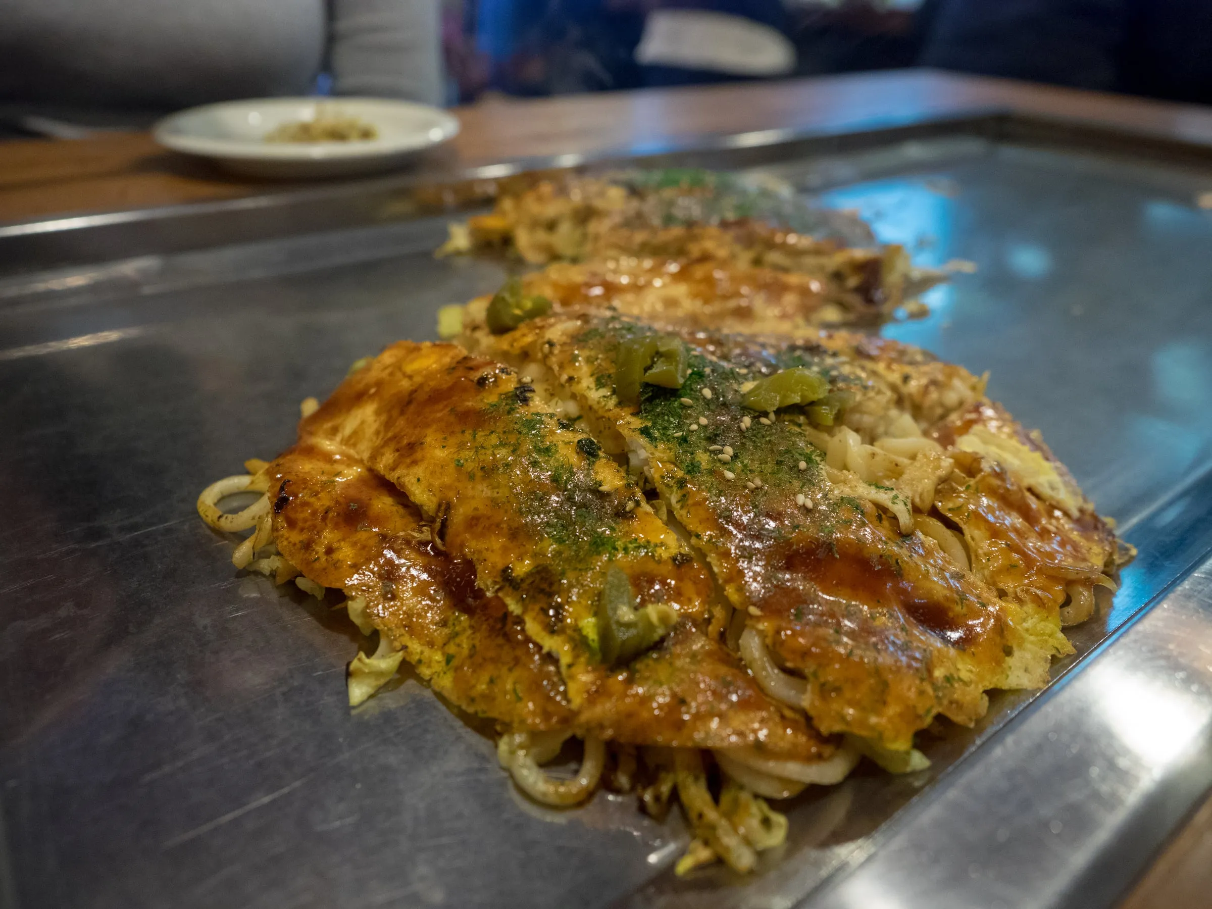 Okonomiyaki à la mode de Hiroshima en couches de chou et de nouilles, le plat emblème de la ville