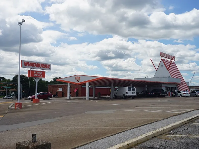 Guide Whataburger Houston : un restaurant de la chaîne au toit en A rayé orange et blanc, avec son panneau « 24 Hour Service », photographié à Mesquite, au Texas