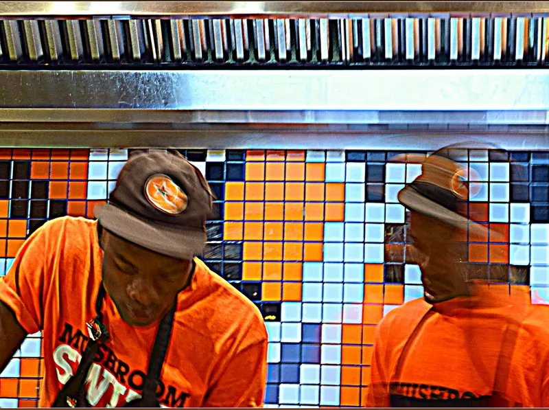 Chefs in the open kitchen of a RocoMamas smash burger restaurant in South Africa, illustrating the RocoMamas Johannesburg chain