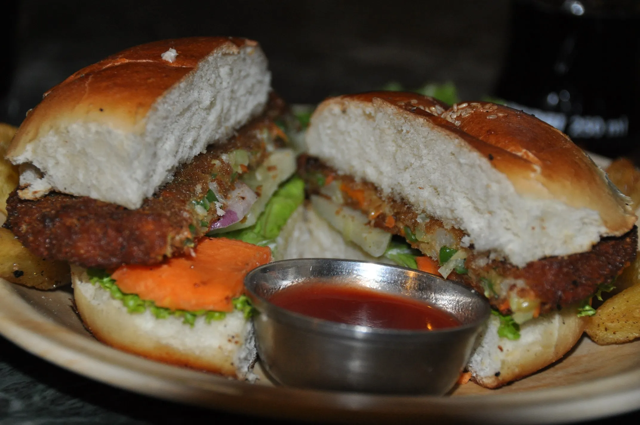 Hamburguesa vegetal empanada con patatas gajo y kétchup en un restaurante de Katmandú