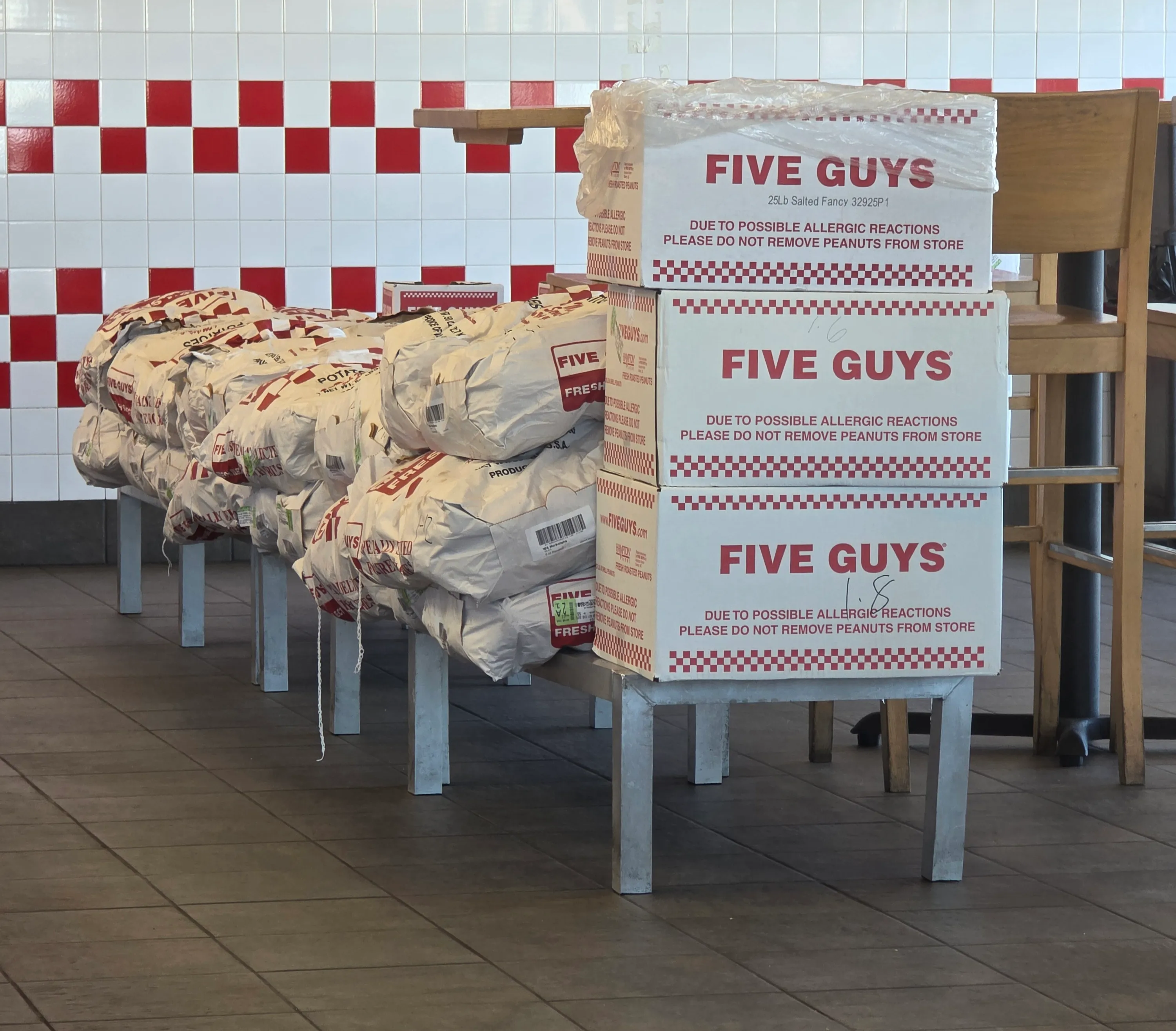 Sacks of potatoes and peanuts stacked inside a Five Guys restaurant