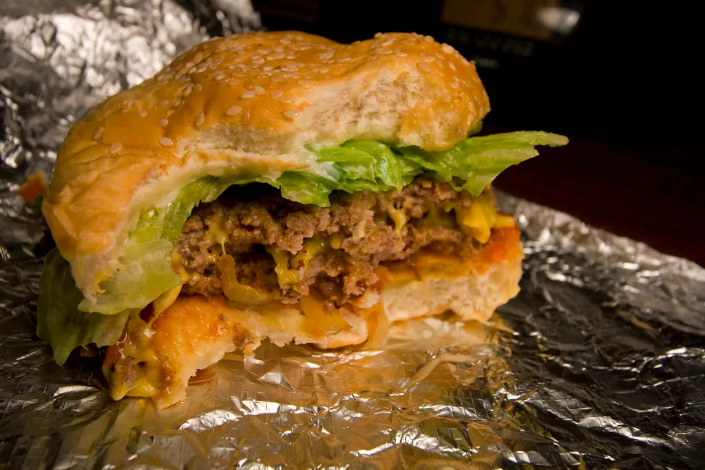 Five Guys bacon cheeseburger with lettuce, ketchup, mustard and grilled onions