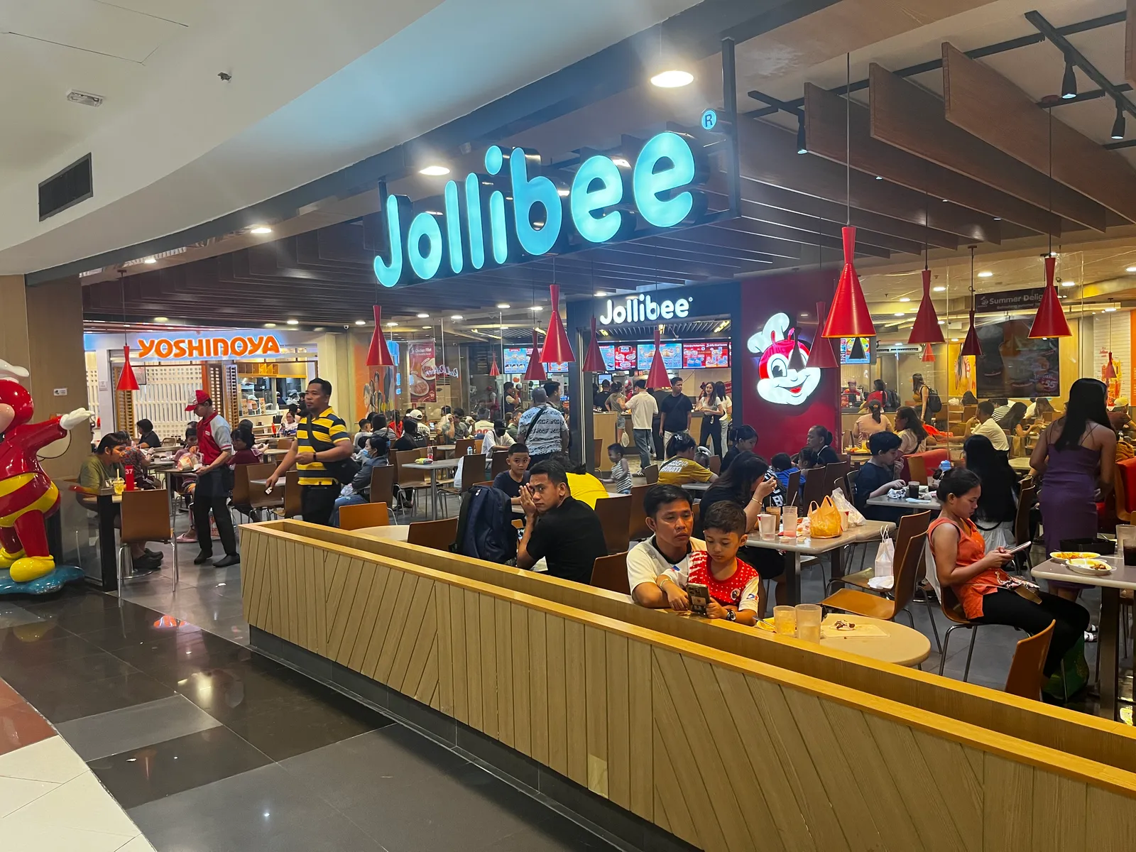 Jollibee Manila branch at Robinsons Place in Ermita, with the lit-up Jollibee sign, the bee mascot and a crowded dining room