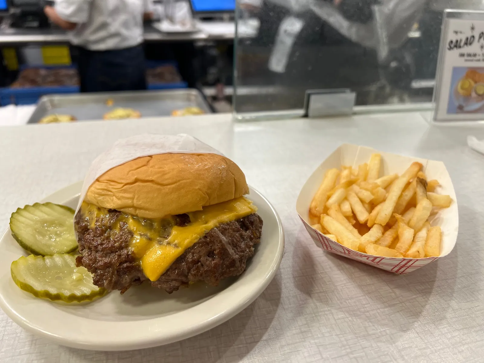 Onion burger façon Oklahoma au fromage américain fondu avec des frites, le style du John T. Burger de Hog & Hominy à Memphis