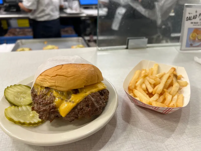 Onion burger façon Oklahoma au fromage américain fondu avec des frites, le style du John T. Burger de Hog & Hominy à Memphis