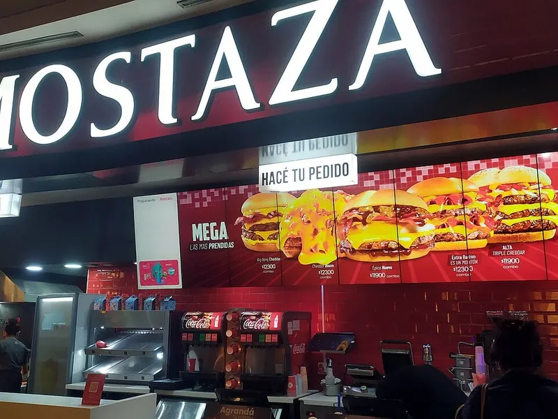 Comptoir Mostaza avec son enseigne rouge et ses menus lumineux dans l'aire de restauration d'un centre commercial, la chaîne de burgers argentine qui compte au moins huit locaux dans la province de Mendoza (photo : Dot Baires Shopping, Buenos Aires)