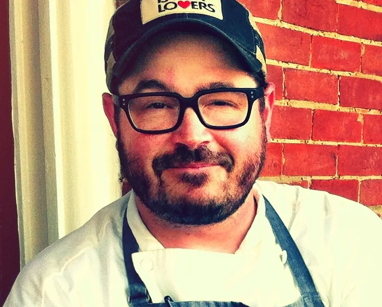 Chef Sean Brock, founder of the Joyland Nashville burger counter, in a chef's jacket and apron in 2013
