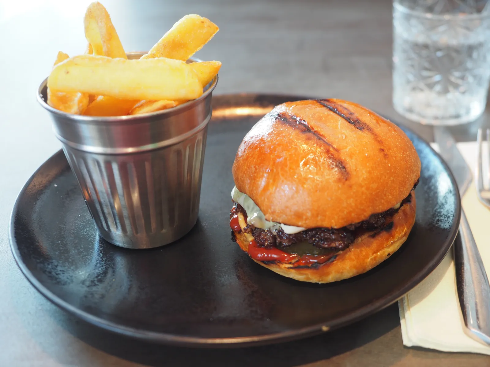 Double smash burger with melted cheese on a toasted brioche bun, the smash burger style Junk serves in Paris