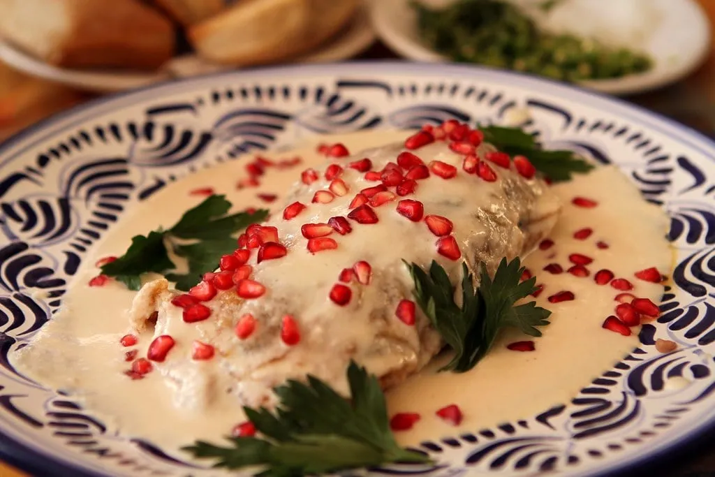 Chile en nogada : piment poblano farci de picadillo, nappé de sauce aux noix et parsemé de grenade (photo d’illustration)