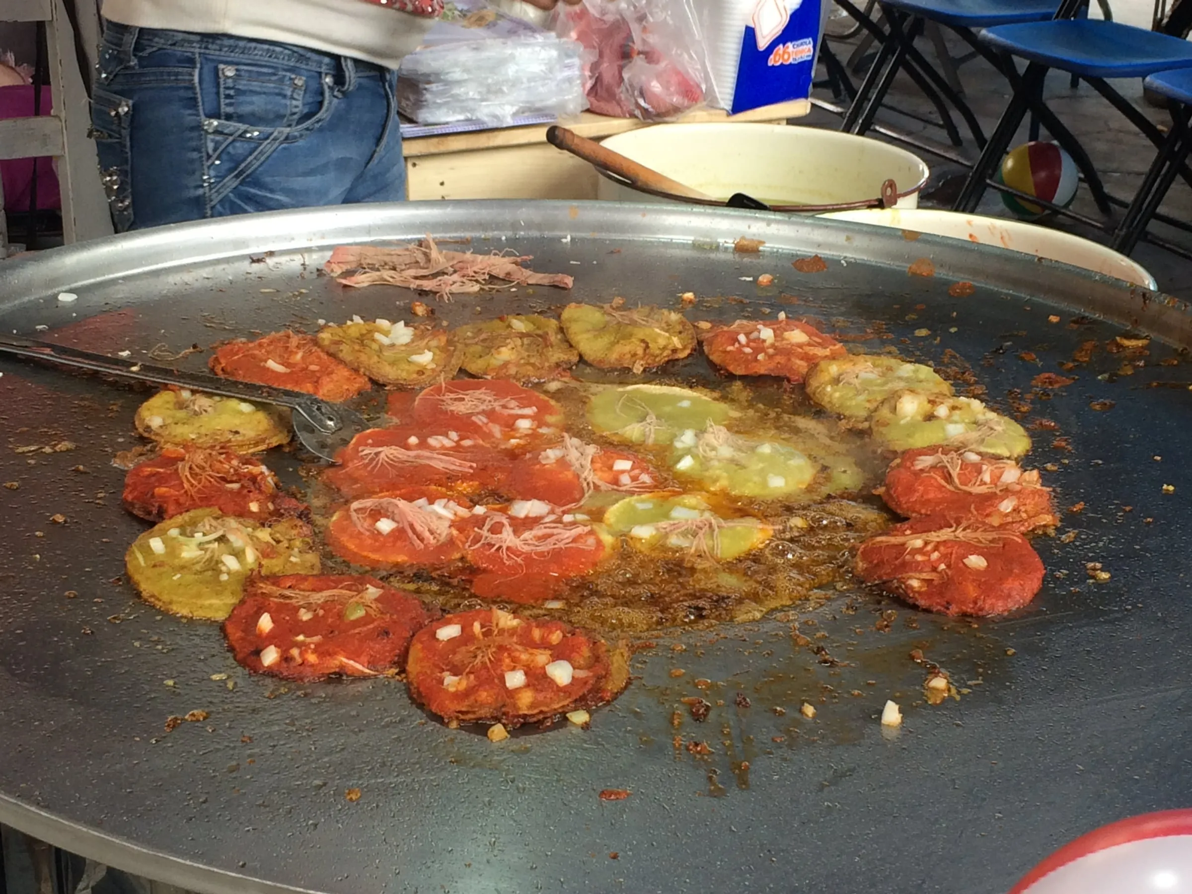 Chalupas poblanas sur le comal d’un stand du Barrio de Analco à Puebla, petites tortillas frites à la sauce rouge et verte